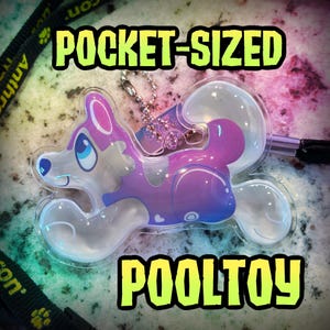 Puede incluir: Un juguete de piscina inflable transparente en forma de animal, de tamaño bolsillo, con un degradado morado y azul, detalles blancos y una cadena de bolas plateada. El texto POCKET-SIZED POOLTOY aparece en letras amarillas grandes.