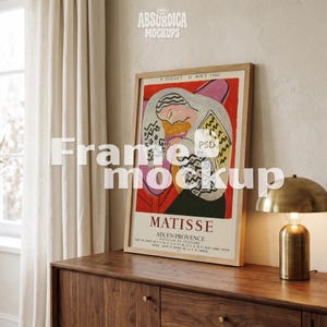 May include: A framed art print featuring a Matisse exhibition poster from Aix-en-Provence. The poster displays a stylized figure in a patterned garment against a red background, with the text 8 JUILLET - 31 AOUT 1960 and MATISSE printed.