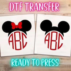 May include: Two white DTF transfer sheets featuring black mouse ear silhouettes with red circular monogrammed letters ABC. One silhouette includes a red bow. The text DTF TRANSFER appears at the top and READY TO PRESS at the bottom.