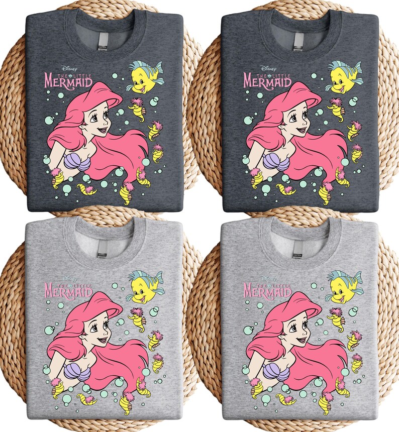 Retro vintage Ariel The Little Mermaid shirt featuring a nostalgic design with Ariel and Flounder. Made from soft, comfortable fabric for all-day wear. Perfect for Disney fans, princess lovers, and classic animation enthusiasts. Great for theme park visits, casual outfits, or as a unique gift. Available in multiple sizes and colors to match any style. A stylish and fun way to showcase love for this beloved Disney character.