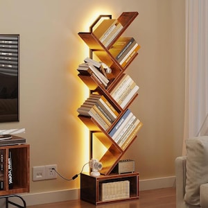 May include: A modern, zig-zag design bookshelf made of dark wood, illuminated by a warm light. The shelves hold various books, and a small clock and basket are on the base. The Criss Cross logo is visible in the top left corner.