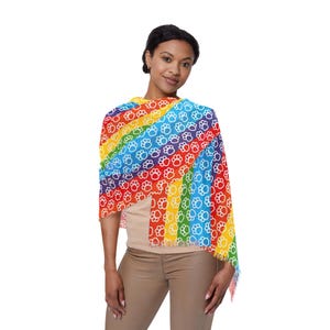 Könnte beinhalten: Ein Regenbogen-Schal mit Pfotenmuster. Der Schal zeigt ein lebendiges Farbspektrum, darunter Rot, Orange, Gelb, Grün, Blau und Lila, mit weißen Pfotenabdrücken. Der Schal ist an den Enden gefranst.