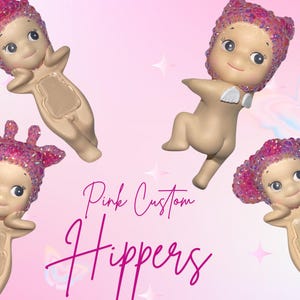 Puede incluir: Cuatro figuras rosas personalizadas con tocados brillantes y una expresi&oacute;n sonriente. Las figuras est&aacute;n en varias poses sobre un fondo rosa con el texto "Pink Custom Hippers".