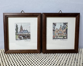 Par de pequeños grabados antiguos coloreados a mano que representan una escena callejera de Frankfurt, firmados, de 4,5" x 5".