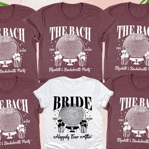 May include: A collection of t-shirts, including a white one, with the text "BRIDE" and "Happily Ever After". The other shirts are maroon and say "THE BACH" with "Elizabeth's Bachelorette Party" and the year 2026. Accessories include shoes, a wine glass, and a bottle of wine.