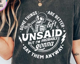 May include: Pepper-colored t-shirt with a white graphic featuring a skeleton and the text "Some things are better left unsaid but I'm probably gonna say them anyway." The shirt has a crew neck and short sleeves.
