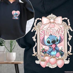 Puede incluir: Sudadera con capucha negra con un gr&aacute;fico de Stitch en la espalda y una versi&oacute;n m&aacute;s peque&ntilde;a en la parte delantera. El gr&aacute;fico de la espalda incluye un lazo rosa, la palabra "Stitch" y fresas. El gr&aacute;fico frontal es un coraz&oacute;n con Stitch.