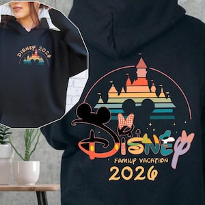 May include: Black hoodie with a colorful Disney castle design and the text "Disney Family Vacation 2026." The front of the hoodie features a smaller design with the text "Disney 2026." The design includes Mickey and Minnie Mouse.