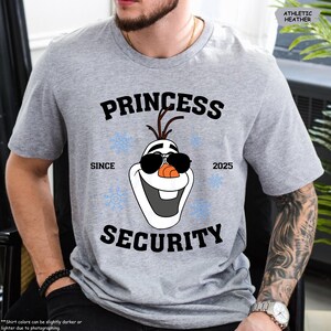 May include: A gray t-shirt with a black graphic of Olaf from Frozen wearing sunglasses. The text "Princess Security" is above Olaf and "Since 2025" is below him.