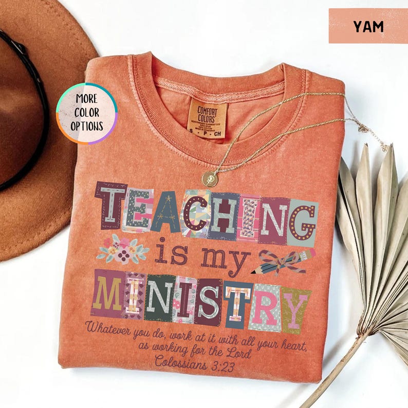 Pu&ograve; includere: Una maglietta color igname con le parole "TEACHING is my MINISTRY" in lettere a blocchi colorate. La maglietta include il versetto biblico Colossesi 3:23. Sono visibili anche una collana d'oro e un cappello marrone.