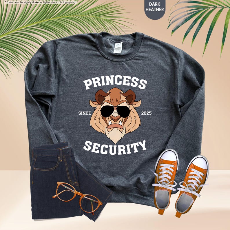 May include: Dark heather grey sweatshirt with a white graphic of a cartoon Beast from Beauty and the Beast wearing sunglasses. The graphic says "Princess Security" with the words "Since" and "2025" on either side of the graphic.