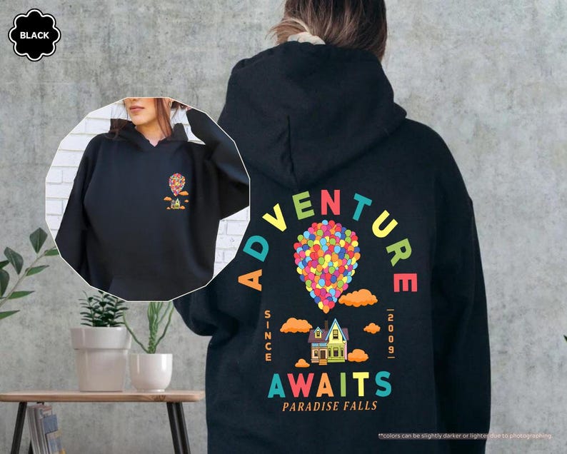Puede incluir: Sudadera con capucha negra con un gr&aacute;fico colorido en la espalda que dice "Adventure Awaits Paradise Falls" con un dise&ntilde;o de casa y globo. La parte delantera de la sudadera tiene una versi&oacute;n m&aacute;s peque&ntilde;a del gr&aacute;fico. La sudadera tiene una capucha con cord&oacute;n.