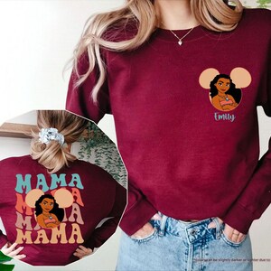 May include: Maroon sweatshirt featuring a cartoon character design with the name "Emily" below. The back of the sweatshirt displays the word "MAMA" in a layered design. The sweatshirt is made of a soft material.
