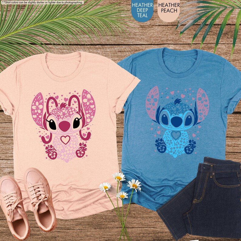 May include: Two t-shirts, one peach and one teal, each featuring a cartoon character design. The peach shirt has a pink character design, and the teal shirt has a blue character design. The shirts are displayed with jeans and shoes.