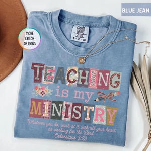 Pu&ograve; includere: T-shirt blu jeans con le parole "TEACHING is my MINISTRY" in lettere a blocchi colorate. La maglietta presenta anche il testo "Whatever you do, work at it with all your heart, as working for the Lord Colossians 3:23". Una collana d'oro &egrave; appoggiata sulla maglietta.