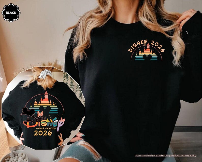 May include: Black sweatshirt with a colorful Disney castle and rainbow design. The front features "Disney 2026" in orange. The back has a larger design with Mickey and Minnie Mouse, the words "Disney Family Vacation 2026".