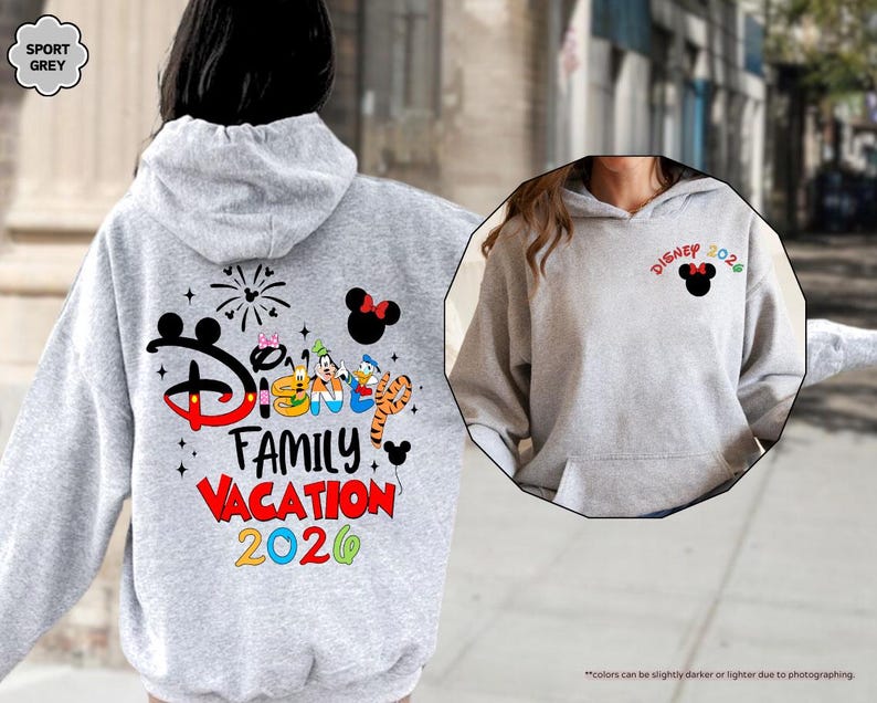 Puede incluir: Una sudadera con capucha gris sport que presenta un gr&aacute;fico en la espalda con el texto Disney Family Vacation 2026, orejas de Mickey Mouse, fuegos artificiales y personajes animados. El pecho muestra un peque&ntilde;o logo Disney 2026 con orejas.