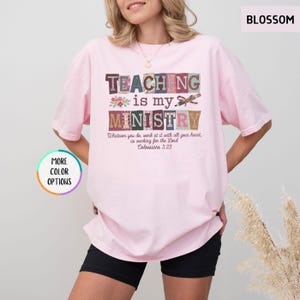 Pu&ograve; includere: Una maglietta rosa chiaro con le parole "TEACHING is my MINISTRY" in lettere a blocchi colorate. La maglietta presenta anche il testo "Whatever you do, work at it with all your heart, as working for the Lord Colossians 3:23."