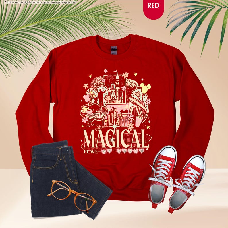 May include: A red sweatshirt with a graphic that says "The Most Magical Place" with a castle and other illustrations. The image also shows a pair of blue jeans, red sneakers, and gold-rimmed glasses.