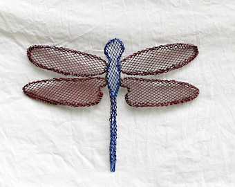 May include: A red and blue metal dragonfly wall decor with a mesh design.