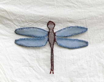 May include: A blue and red metal dragonfly wall decor. The dragonfly has a mesh design and is a great addition to any home decor.