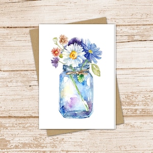 May include: A watercolor painting of a blue glass jar filled with a bouquet of colorful wildflowers. The flowers include white daisies, blue and purple wildflowers, and pink and red wildflowers.