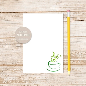 May include: A white notepad with a green coffee cup design and the text "50 SHEET NOTEPAD 4x6 inches". A yellow pencil is on the right side of the notepad.