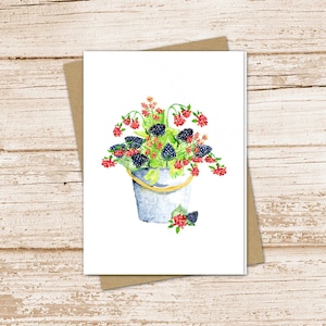 May include: A watercolor painting of a white bucket filled with blackberries and red flowers. The bucket is sitting on a white background.