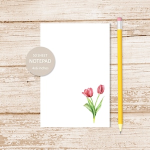 Pode incluir: Um bloco de notas branco com uma ilustra&ccedil;&atilde;o de tulipa rosa. O bloco de notas mede 10,16 x 15,24 cm e tem 50 folhas.
