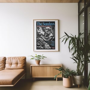 K&ouml;nnte beinhalten: Gerahmtes Poster mit dem Text "The Sundays" in Blau, mit einem Schwarz-Wei&szlig;-Bild einer Statue und Text. Das Poster befindet sich in einem hellen Holzrahmen und h&auml;ngt an einer wei&szlig;en Wand. Darunter befinden sich ein braunes Ledersofa und ein Holzschrank.