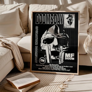 Könnte beinhalten: Gerahmtes Schwarz-Weiß-Poster mit dem Text "DOOMSDAY" und "MF DOOM". Das Poster zeigt eine stilisierte Maskengrafik und zusätzlichen Text, darunter "OPERATION: DOOMSDAY" und "1999".