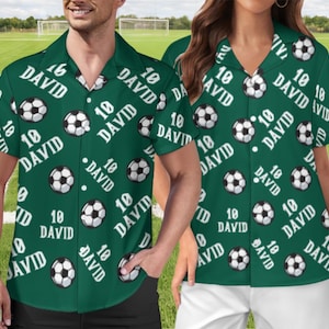 May include: Green button-down shirt with a soccer ball pattern and the name "DAVID" and the number "10" in white. The shirt is short-sleeved and has a classic collar. The background shows a soccer field.