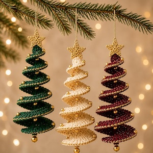 May include: Three spiral-shaped Christmas tree ornaments made of crocheted yarn in dark green, cream, and deep red. Each ornament features a gold crocheted star at the top, small gold beads along the spiral edges, and a gold bead at the bottom.