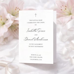 May include: A white wedding invitation with elegant script. The text includes the names Isabella Grace and Daniel Anderson, along with the date March 18, 2026, and the location, The Ivory Chapel, California, USA. A cross is at the top.