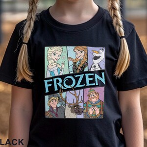 May include: Black t-shirt with a colorful graphic of characters from the movie Frozen. The graphic includes Elsa, Anna, Olaf, Kristoff, Sven, and a snowman. The text "FROZEN" is printed in blue across the graphic.