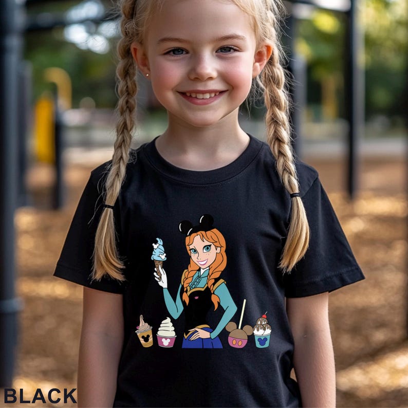 以下が含まれることがあります： アイスクリームコーンを持った漫画のキャラクターと、その下にアイスクリームのグラフィックが描かれた黒いTシャツ。Tシャツの下部には「BLACK」の文字がプリントされています。キャラクターは赤い髪で、黒いミッキーマウスの耳のカチューシャをしています。