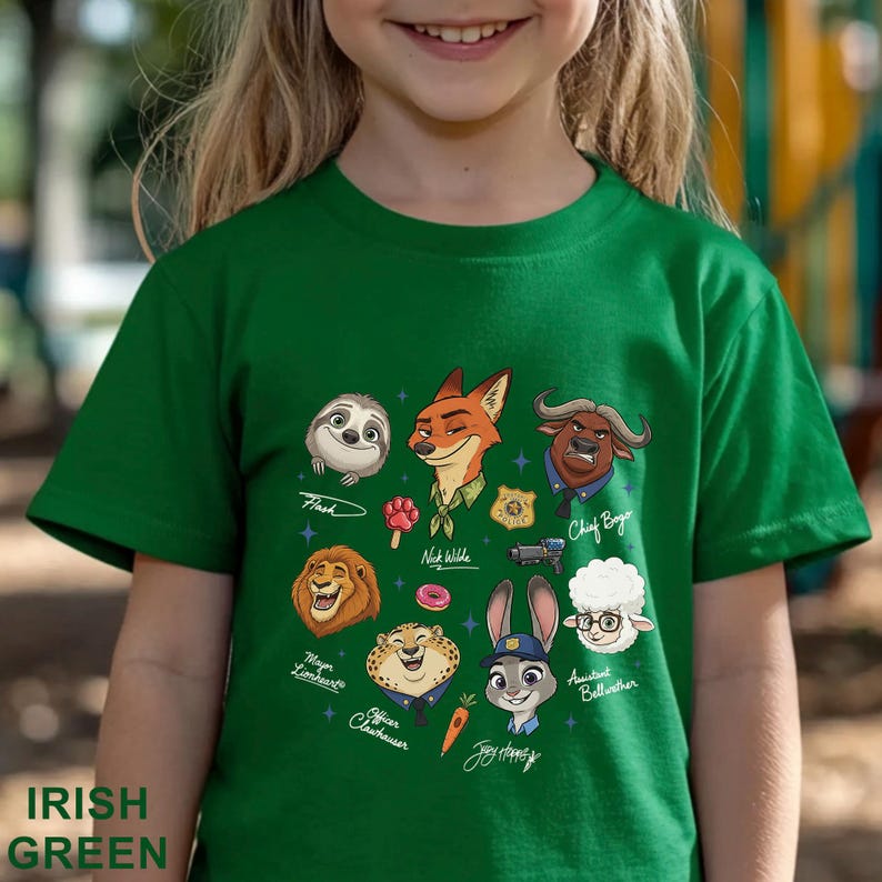 Pu&ograve; includere: T-shirt verde irlandese per bambini con personaggi dei cartoni animati di Zootropolis, tra cui Flash, Nick Wilde e Judy Hopps. La maglietta ha le parole "Irish Green" stampate in basso. Il design include vari personaggi e i loro nomi.