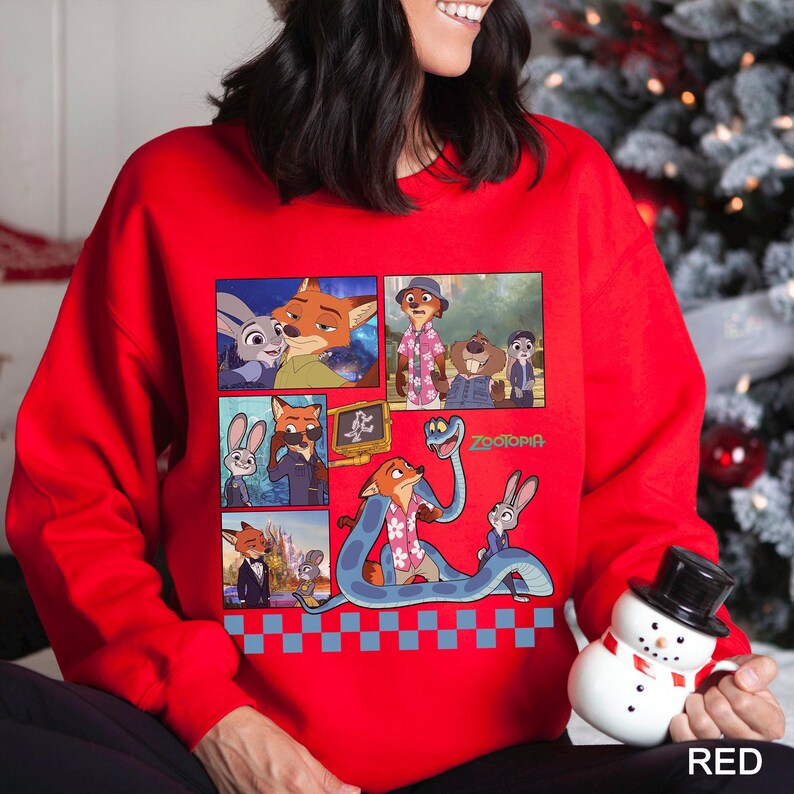 May include: A bright red long-sleeve sweatshirt featuring a graphic print of characters from the movie Zootopia. The design includes multiple panels showing scenes with Nick Wilde and Judy Hopps, along with a blue snake and the Zootopia logo.