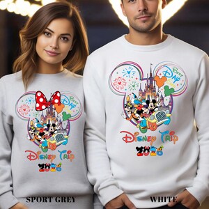 May include: Sport grey and white sweatshirts with a colorful Disney Trip 2020 design. The design features Mickey Mouse, Minnie Mouse, and other Disney characters in a car, with a castle and fireworks.