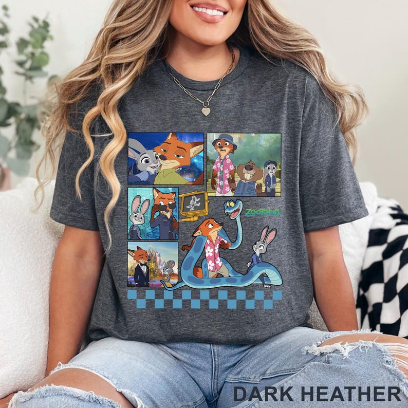 Pu&ograve; includere: T-shirt grigio scuro con una grafica colorata dei personaggi del film d'animazione "Zootopia". Il design include pi&ugrave; pannelli con immagini dei personaggi, con la parola "Zootopia" in verde. Il testo "DARK HEATHER" &egrave; in basso.