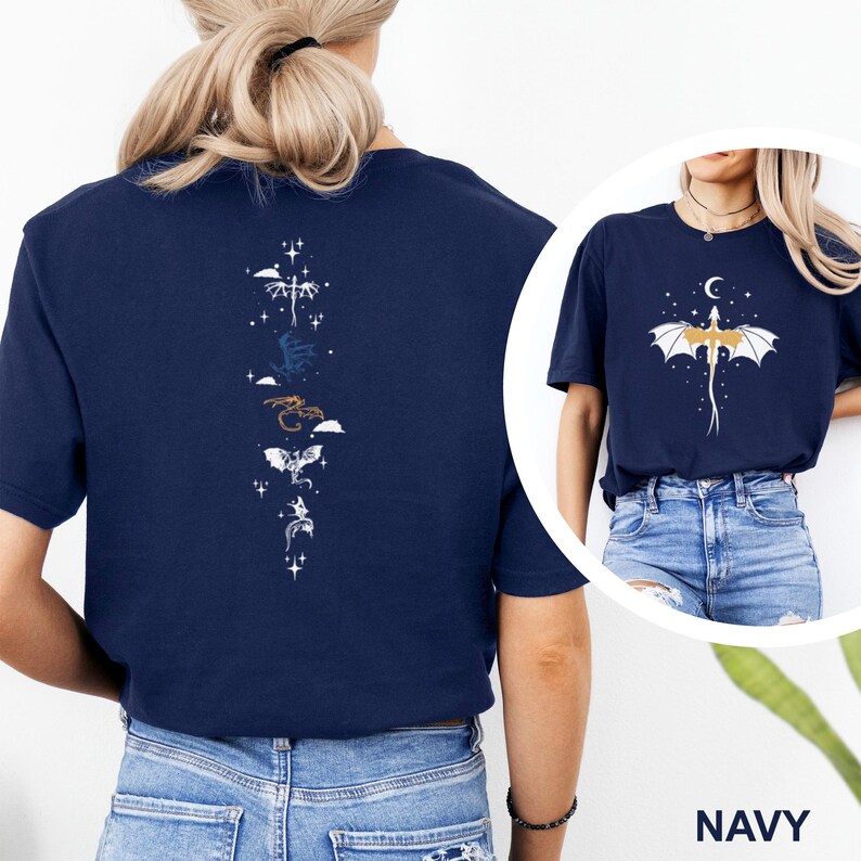 Pu&ograve; includere: T-shirt blu navy con un design a forma di drago. La parte posteriore della maglietta mostra una disposizione verticale di draghi stilizzati in bianco, blu e oro, con stelle. La parte anteriore ha un drago con una luna crescente e stelle.