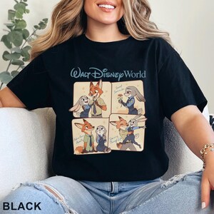 Puede incluir: Camiseta negra con una ilustraci&oacute;n de cuatro paneles de los personajes de Zootopia, Nick Wilde y Judy Hopps. El texto "Walt Disney World" es de color azul claro. La palabra "BLACK" est&aacute; en la esquina inferior izquierda de la camiseta.
