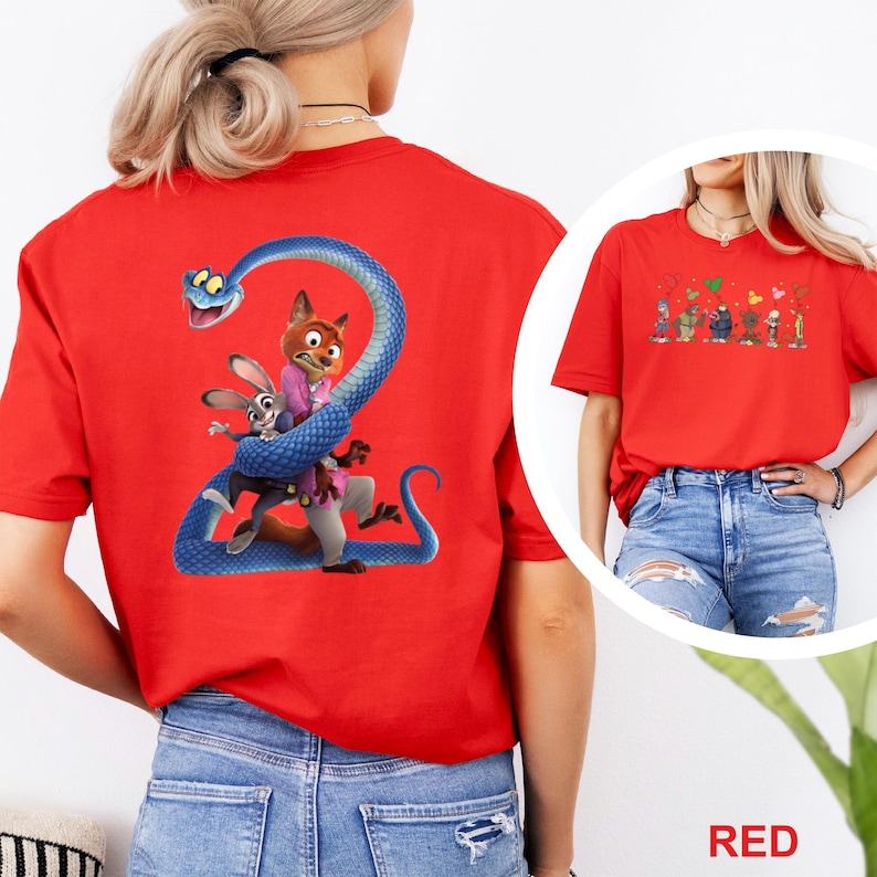 K&ouml;nnte beinhalten: Rotes T-Shirt mit einem Cartoon-Motiv eines Fuchses, Kaninchens und einer Schlange in Blau, Rosa und Braun. Eine kleinere Grafik von Cartoon-Charakteren ist ebenfalls vorhanden. Das Wort "RED" befindet sich am unteren Rand des Bildes.