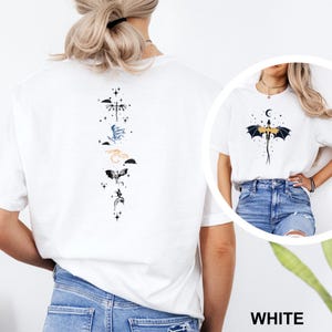 Pu&ograve; includere: T-shirt bianca con grafica di draghi sul davanti e sul retro. Il design posteriore presenta una disposizione verticale di illustrazioni di draghi in vari colori. Il design anteriore presenta un drago con luna crescente e stelle.