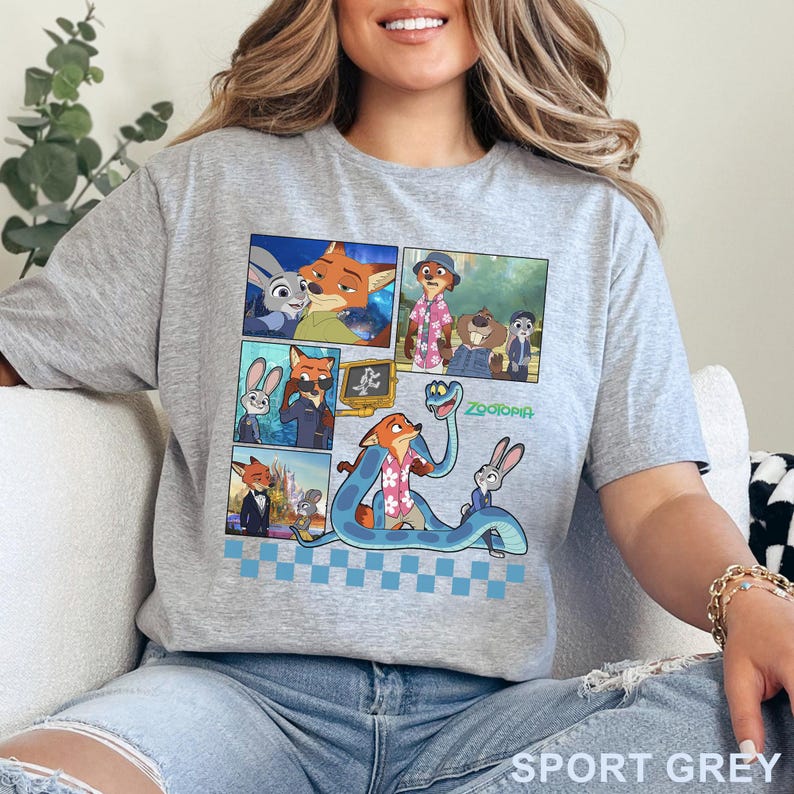 Pu&ograve; includere: T-shirt grigia sportiva con un colorato design a fumetti con personaggi del film d'animazione "Zootopia". Il design include immagini di una volpe, un coniglio e altri personaggi. La parola "Zootopia" &egrave; stampata in verde. La maglietta &egrave; in materiale morbido.