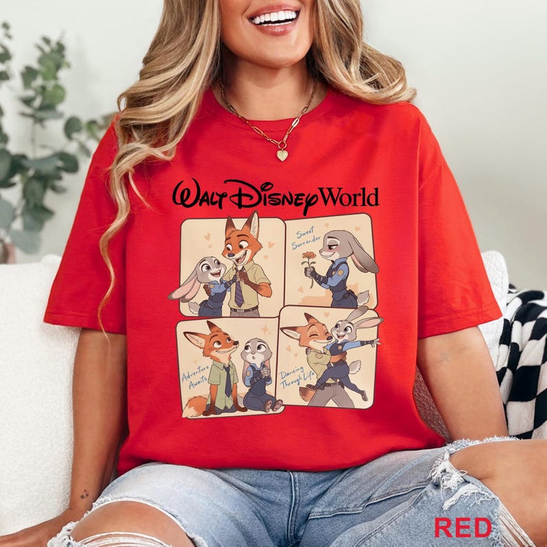Puede incluir: Camiseta roja con un gr&aacute;fico de cuatro paneles de personajes de Zootopia, con el texto "Walt Disney World" en la parte superior. Los paneles muestran a Nick Wilde y Judy Hopps en varias poses. La palabra "RED" est&aacute; en la parte inferior.