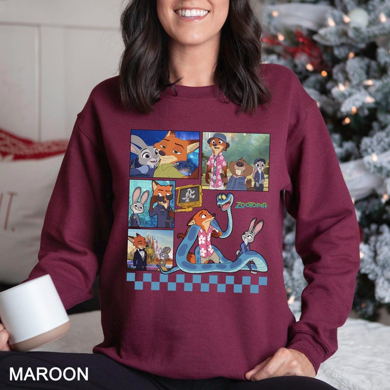 May include: A maroon long-sleeve sweatshirt featuring a graphic print of Zootopia characters including Judy Hopps and Nick Wilde in various scenes, with a blue and white checkered border at the bottom and the Zootopia logo in green text.