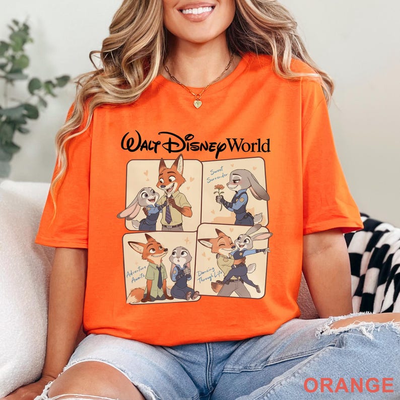 Puede incluir: Camiseta naranja con un dise&ntilde;o de Walt Disney World. El dise&ntilde;o presenta im&aacute;genes de dibujos animados de un zorro y un conejo en varias poses, con texto como "Sweet Surrender" y "Adventure Awaits".