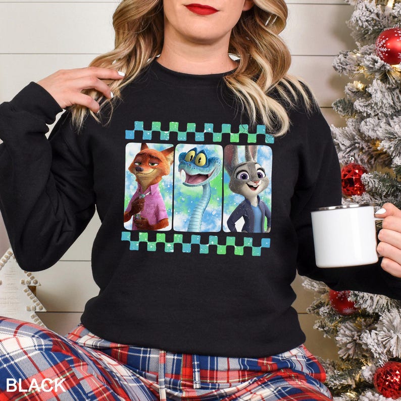 May include: Black crew neck sweatshirt with a graphic of three Zootopia characters in a checkered frame. The word "BLACK" is printed at the bottom. The sweatshirt is a casual style.