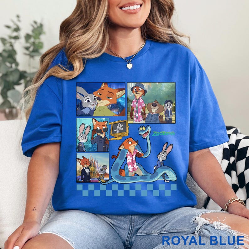 Pu&ograve; includere: T-shirt blu reale con una grafica colorata dei personaggi del film d'animazione "Zootropolis". Il design include immagini di una volpe, un coniglio e altri personaggi. Il testo "Zootopia" &egrave; visibile. La maglietta &egrave; realizzata in materiale morbido.
